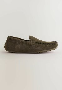 Mocassin à enfiler en daim marron avec coutures apparentes et semelle en caoutchouc à picots antidérapants, présenté en profil latéral sur fond uni.