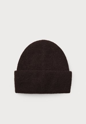 Bonnet en laine marron foncé avec un dessus arrondi, présentant un revers replié à la base. La texture semble douce et légèrement pelucheuse.