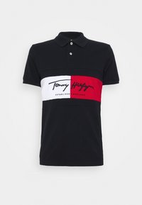 Polo negro de algodón con un diseño horizontal de rayas rojas y blancas, logo bordado y cuello clásico.