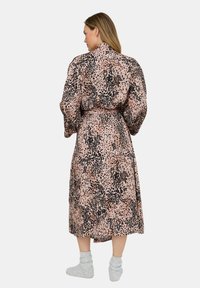 Long, pink robe with a black leopard print pattern. Features puffed sleeves, a belted waist, and a smooth, silky texture.