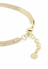 Guldfärgad halsband med en flexibel, platt design. Har en hummerklämma och en förlängningskedja med en cirkulär tagg. Slät, glänsande yta.