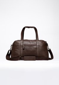 Brown leather duffle bag with dual handles, adjustable shoulder strap, zippered pocket, smooth texture, and vertical stitching accents.