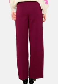 Vínové kalhoty širokého střihu s hladkou texturou a střih na míru, vybavené dvěma zadními kapsami a čistým zakončením lemu.