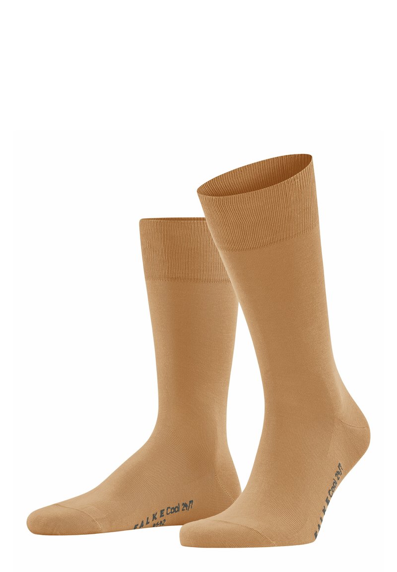 Chaussettes de couleur beige clair, fabriquées à partir d'un matériau doux, avec une texture lisse et un bord côtelé. Présentent un logo bleu sur le côté.