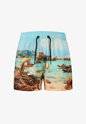 Shorts de bain avec une scène de plage représentant un crocodile détendu portant des lunettes de soleil et un chapeau, tenant un verre, près de l'eau et des rochers.