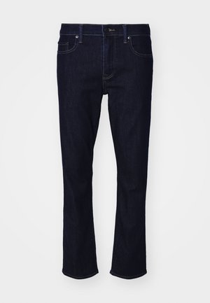 Jeans din denim albastru închis cu un design cu picioare drepte, cinci buzunare și detalii de cusătură subtile. Prezintă un sistem de închidere cu buton și fermoar.