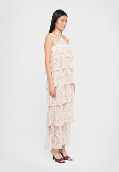 Lace gelaagde jurk in lichtroze met een vloeiende silhouet. Bevat dunne bandjes, bloemenpatronen en een gelaagd ontwerp. Draagt het met open tenen hakken.