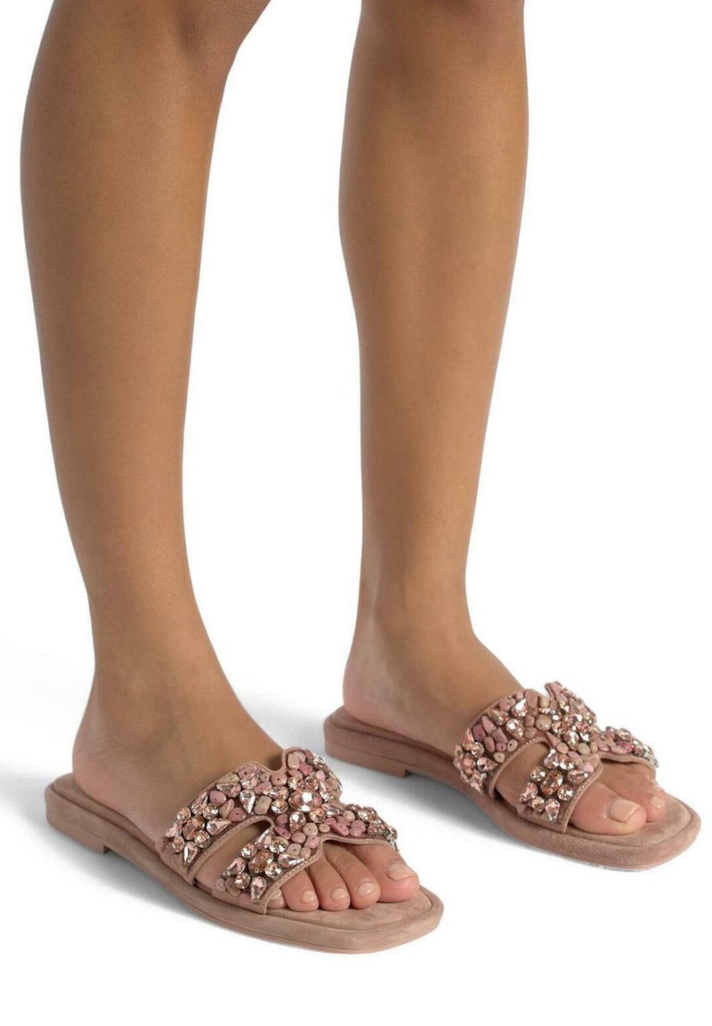 Sandales à glissière roses avec des brides agrémentées de pierres précieuses et de perles, texture en suède doux et semelle plate pour le confort.