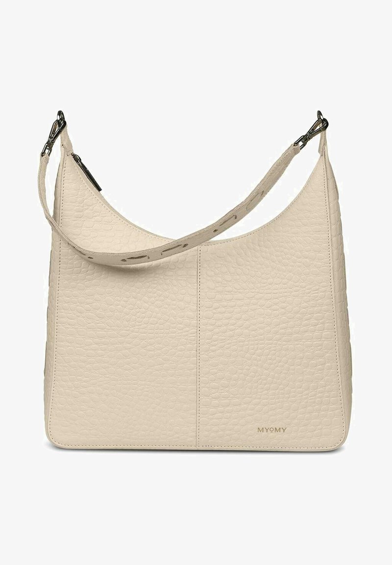 Beige leren handtas met een gestructureerd oppervlak, een gebogen ontwerp en een lange verstelbare schouderriem. Heeft minimalistische branding die op de bodem is geperst.
