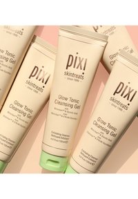 Fem rør med PIXI Glow Tonic Cleansing Gel. Beige rør med grønne hetter, med brun tekst og en jevn matt finish. 135ml hver.