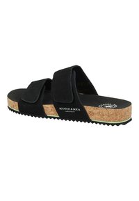 Black suede slide sandals with two adjustable straps, cork midsole, and serrated rubber outsole. Brand logo printed on the side.