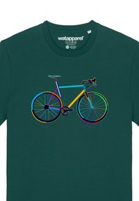Impression graphique d'un vélo dans des couleurs vives sur un t-shirt bleu-vert. Les caractéristiques incluent des roues distinctes, un cadre et des guidons avec des couleurs d'accent variées.