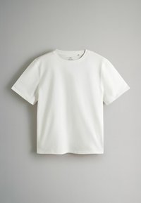 T-shirt blanc uni à manches courtes et col rond, présenté à plat sur un fond gris clair.
