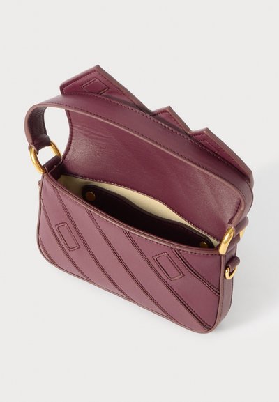 Burgundyröd läderhandväska med ett diagonalt sömmönster, guldfärgade detaljer och ett rymligt inre med en beige foder och tryckknappsstängning.