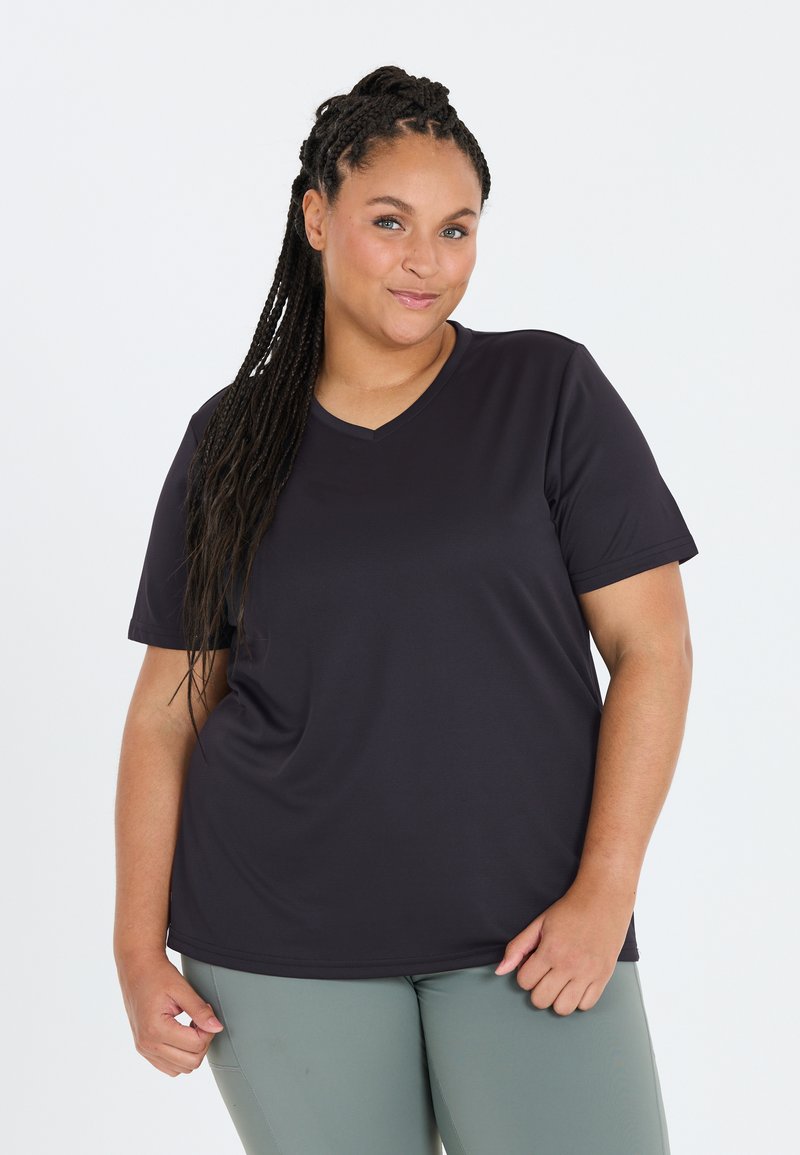 Mørkeblå kortærmet T-shirt med V-udskæring, lavet af et glat, strækbart stof, parret med lysegrønne tætsiddende leggings.