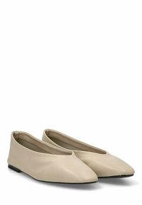 Bailarinas de cuero beige con punta afilada, textura suave y diseño minimalista. Suela de goma negra sin hardware visible.