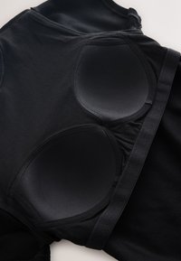 Black bodysuit featuring smooth, molded cups and stretchy, ribbed fabric. The design includes wide straps and sleek seams for a seamless fit.