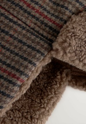 Wollmischgewebe mit einem strukturierten Braun- und Grautarnmuster, das auf einer Kante mit weichem, flauschigem braunem Fleece gefüttert ist.