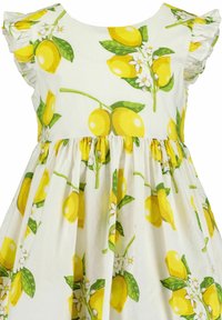 Robe blanche avec un motif floral de citrons. Comprend une jupe froncée, des citrons jaunes vifs, des feuilles vertes et de petites fleurs blanches. Manches volantes.