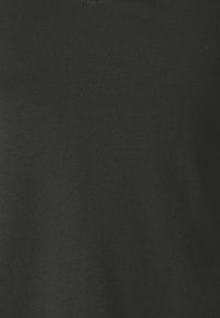 T-shirt en coton noir avec une texture lisse et un col rond. Le tissu semble légèrement extensible, sans motifs ni accents visibles.