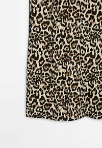 Leopard print fabric, featuring a mix of black and brown spots on a cream background. Texture appears smooth, with a slight sheen.