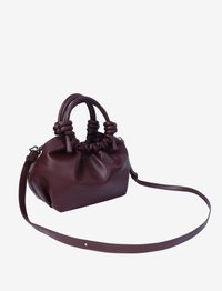 Maroon leather handbag with gathered top, dual handles, and adjustable strap. Smooth texture, rounded shape, and minimalistic design.