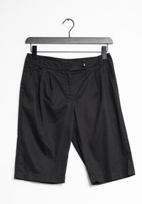 Shorts noirs en tissu léger, dotés d'une fermeture à bouton, de plis à l'avant et de poches latérales. Accrochés à un cintre noir.