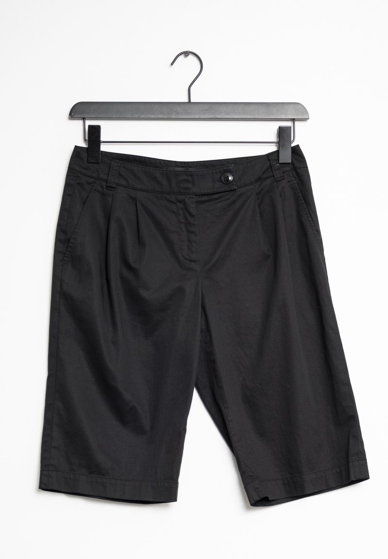 Shorts noirs en tissu léger, dotés d'une fermeture à bouton, de plis à l'avant et de poches latérales. Accrochés à un cintre noir.