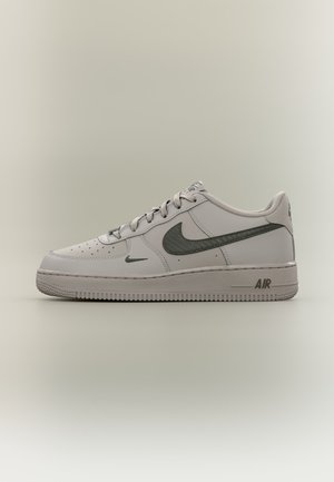 Nízkoprofilová biela teniska so sivým logom Nike swoosh, perforovanou špičkou a označením "AIR" na medzipodrážke, zobrazená z bočného profilu.