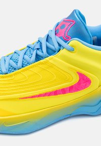 Letvægts sneakers med en gul overdel, blå accenter og pink detaljer. Teksturopfladen med en glat gradient sål.