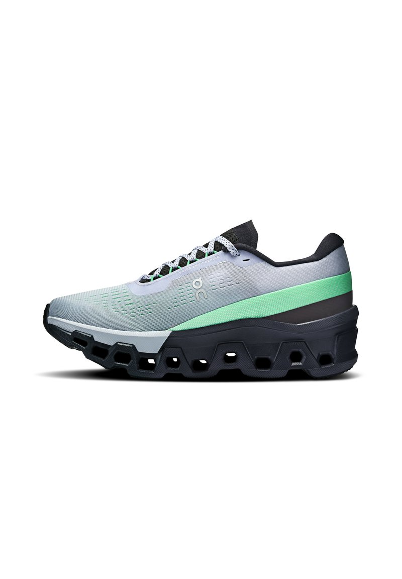 Running shoe in grey with green and black accents. Features a textured mesh upper and thick, segmented sole for cushioning and support.