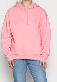 Sudadera rosa claro hecha de material suave, con un bolsillo frontal, capucha con cordón y puños y dobladillo acanalados; corte relajado.