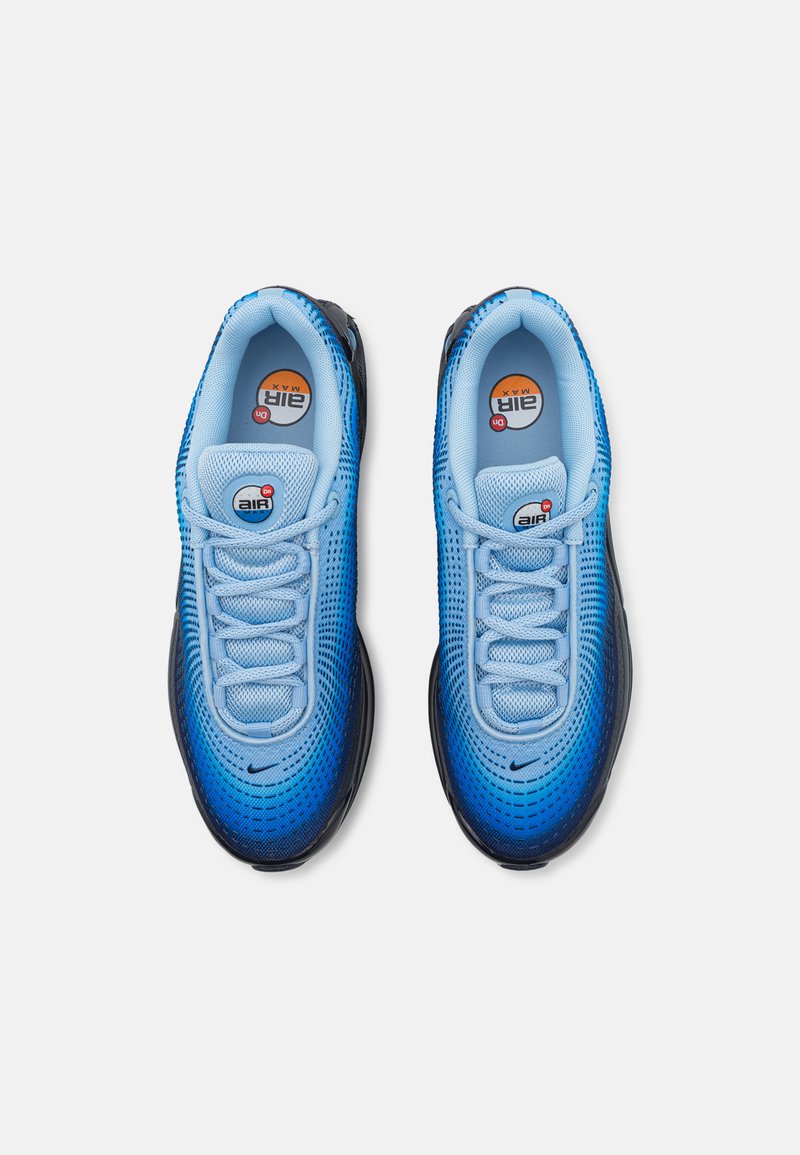 Baskets de sport en dégradé bleu avec un matériau en maille, bout rond, semelle noire et fermeture lacée ; équipées d'un logo sur la languette et d'une texture perforée.