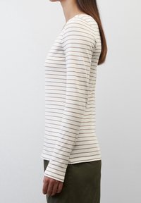 Gestreiftes Langarmshirt in Creme mit hellbraunen horizontalen Streifen. Weicher Stoff, taillierte Passform, Rundhalsausschnitt und gerader Saum.