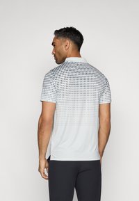 Šviesiai pilkas trumpomis rankovėmis polo marškinėliai, su juodu taškuotu raštu, kuris viršuje pereina į vientisą apačią. Pagaminti iš kvėpuojančios medžiagos su apykakle.