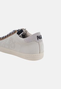 Zapatillas de cuero blancas con acentos de ante marrón, cordones grises texturizados y un cuello a rayas gris. Logo "P448" en el talón. Diseño clásico.