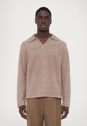 Pullover malha castanho claro com um colarinho largo, padrão de diamante texturizado e mangas compridas, combinado com calças bege.