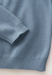 Maglione lavorato a maglia azzurro chiaro con orlo e polsini a costine. Il materiale ha una texture fine e presenta un design semplice senza fantasie o accessori.