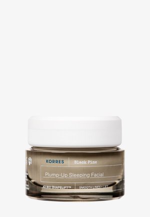 Korres Black Pine Plump-Up Sleeping Facial w przezroczystym słoiku z białą pokrywką; posiada okrągły kształt i nadrukowane etykiety na pojemniku.