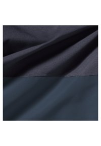 Dunkelblauer und marineblauer Stoff mit sichtbarer Struktur und weichen Falten, die eine horizontale Naht zwischen den beiden Farbabschnitten zeigen.
