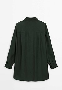 Tummanvihreä pitkähiha paita, joka on tehty kevyestä kankaasta. Siinä on kaulus, napilliset kalvosimet, rento istuvuus ja hienovarainen tekstuuri.