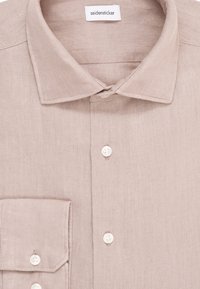 Lichtbeige linnen shirt met een puntige kraag, een knoopsluiting aan de voorkant en een zak op de linkerkant van de borst. Kenmerkt zich door witte knopen en een gestructureerde stof.