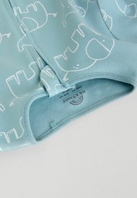 Light blue fabric with white elephant print. Features smooth texture, rounded edges, and a visible branding label on the inside.