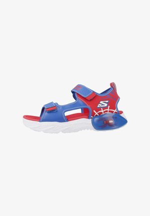 Kindersandaal met open teen in blauw en rood met verstelbare riempjes, witte zool, spinnenafbeelding en spinnenwebdesign op de hiel.