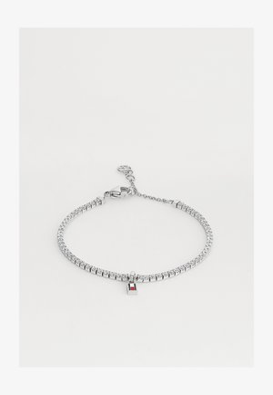 Ασημένιο μπρασελέ τένις με μικρές διαφανείς πέτρες και μικρό ορθογώνιο κρεμαστό με κόκκινες και λευκές ρίγες.