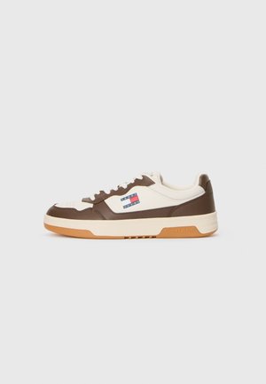 Low-top sneaker in cream and brown leather with white laces, gum sole, and Tommy Jeans logo on the side against a white background.
