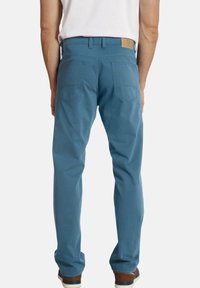 Blaue Baumwollhose mit geradem Bein, ausgestattet mit zwei Gesäßtaschen und einem Lederetikett am Bund.