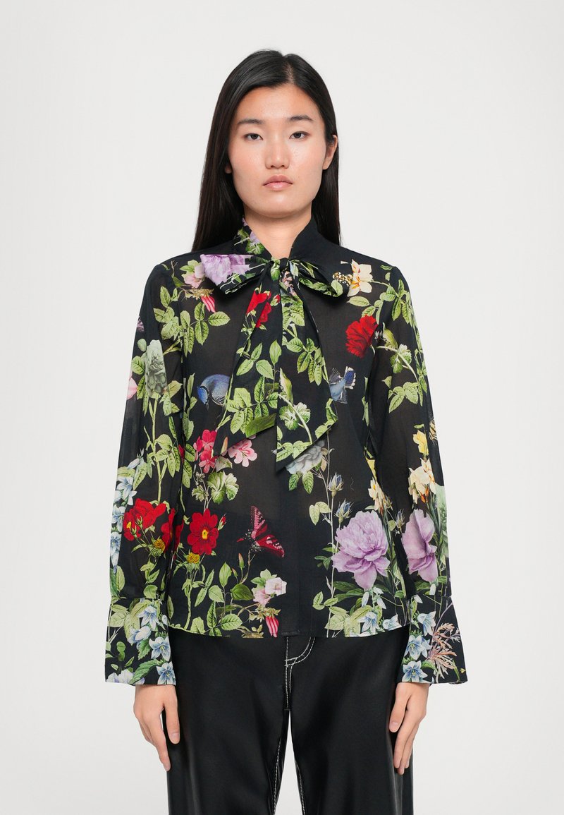Black blouse with floral print in vibrant colors. Features long sleeves, a tied collar, and a lightweight, sheer fabric texture.