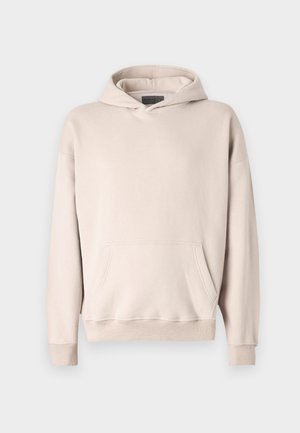 Sweatshirt à capuche beige clair en tissu doux. Équipé d'une poche kangourou, de poignets côtelés et d'une coupe décontractée.