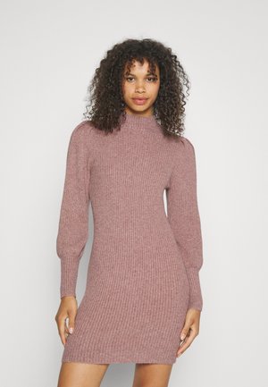 Robe en tricot côtelé de couleur mauve doux, avec un col haut, des manches bouffantes longues et une silhouette ajustée. Elle arrive au genou et est fabriquée dans un tissu texturé.